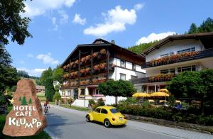 ein kleines gelbes Auto, das vor einem Hotel parkt in der Unterkunft Schwarzwaldhotel Klumpp in Baiersbronn