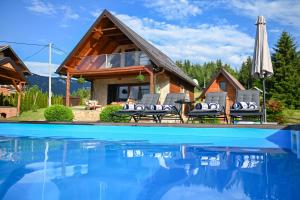 a house with a pool and chairs and an umbrella at Country Chic Villa with Pool in Mrginj