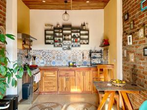 a kitchen with wooden cabinets and a brick wall at Nativo Lodge in Playas