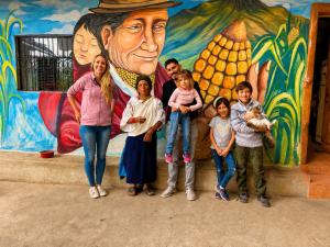 a group of people standing in front of a mural at Loma Wasi, Experiencia Rural Kichwa in Cotacachi