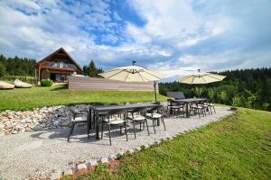 a group of tables and chairs with umbrellas at Country Chic Villa with Pool in Mrginj