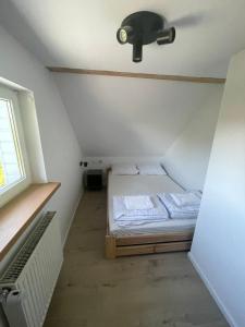 a small room with a bed and a window at Sielankowo in Rożnów