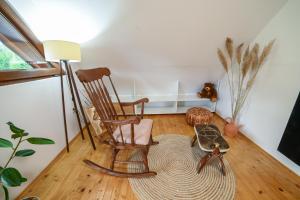a rocking chair in a living room with a floor at Country Chic Villa with Pool in Mrginj
