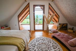 a bedroom with large windows and a bed and a rug at Country Chic Villa with Pool in Mrginj +63 photos
