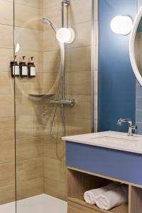 a bathroom with a shower and a sink at BATTURES Hotel Fjord Saguenay in La Baie