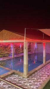 a building with lights in the water at night at Ali in Mawāliḩ