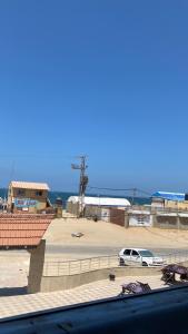 a car parked in a parking lot next to the ocean at Ali in Mawāliḩ