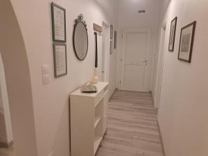 a hallway with white walls and a mirror and a table at ALSIDE Apartment in Aegiali +100 photos