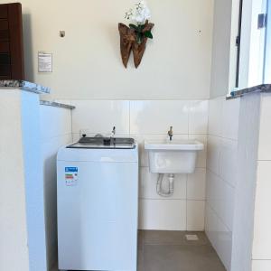 a small bathroom with a sink and a refrigerator at Apartamento com 2 quartos próximo do centro in Sinop