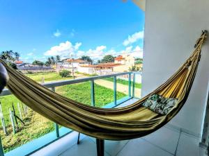 a hammock on a balcony with a view at Sol, Mar e Tranquilidade a poucos passos do Caminho de Moisés com Varanda Privativa e Estacionamento in Maragogi