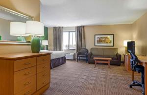 a hotel room with a bedroom with a bed and a couch at Extended Stay America Select Suites - Madison - Old Sauk Rd in Madison