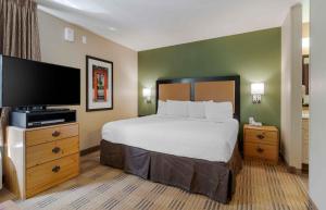 a hotel room with a bed and a flat screen tv at Extended Stay America Select Suites - Atlanta - Marietta - Wildwood in Atlanta