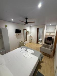 a bedroom with a bed and a living room at kitnet Residencial Ozzy com Garagem Coberta em Betim in Betim