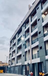 a tall building with people standing in front of it at Appart lotus in Cocody