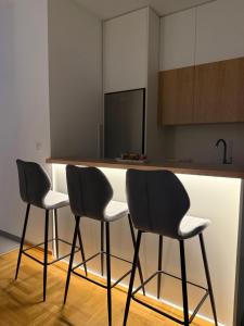 a kitchen with a counter with three chairs around it at El Paso Grande in Ledine