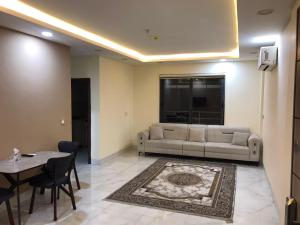 a living room with a couch and a table at موتيل روزا عينكاوا in ‘Aynkāwah