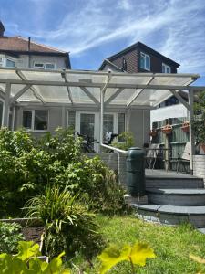 a white pergola on a house at King room with garden access in Raynes Park