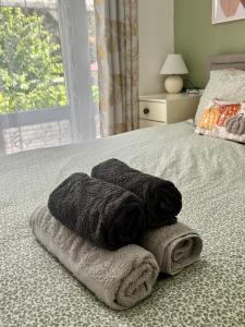 a pile of towels sitting on top of a bed at King room with garden access in Raynes Park