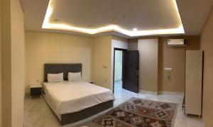 a bedroom with a bed in a room with a rug at موتيل روزا عينكاوا in ‘Aynkāwah