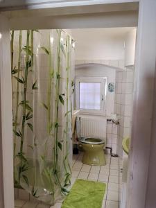 a bathroom with a toilet and a shower curtain with bamboo at BLR Apartment in Graz +14 photos