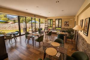a restaurant with tables and chairs and large windows at Sierra Sacred Valley in Urubamba +39 photos
