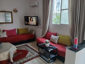 a living room with two red couches and a window at إقامة تسنيم in Selouane