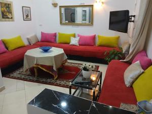 a living room with a red couch and colorful pillows at إقامة تسنيم in Selouane +1 photo