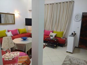 a living room with a red couch and a table at إقامة تسنيم in Selouane