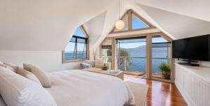 a bedroom with a large bed and a large window at Casa Con Vista Luxury Waterfront Home, Sleeps 10 in Hobart