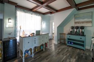 a room with a dresser and a table and a window at Silver Lining Inn and Motel in Chéticamp