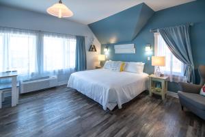 a blue bedroom with a bed and a couch at Silver Lining Inn and Motel in Chéticamp