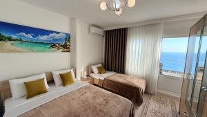 a hotel room with two beds and a large window at Sea&Sun Living in Ulcinj