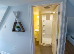 a hallway with a bathroom with a toilet in it at Silver Lining Inn and Motel in Chéticamp +87 photos