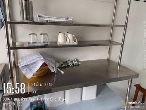 a shelf in a kitchen with a table with cups at Ao Nang Room And Bike 10 in Ao Nang 