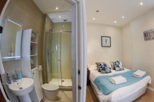 ein Badezimmer mit einem Bett, einer Dusche und einem Waschbecken in der Unterkunft Finchley Central Spacious 3 bed triplex loft style apartment in Hendon