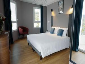 a bedroom with a white bed and a red chair at Four-Guest Getaway in Chatel-Guyon in Châtel-Guyon +20 photos