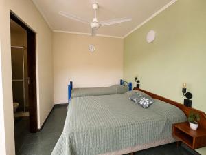 a bedroom with a bed and a ceiling fan at Hostel & Posada Noelia in Puerto Iguazú