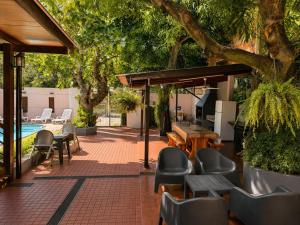 a patio with chairs and tables and a pool at Hostel & Posada Noelia in Puerto Iguazú
