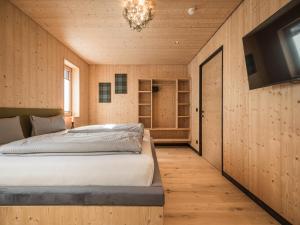 a bedroom with a bed and a flat screen tv at Bichlbach Chalet with sauna in Bichlbach