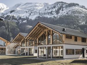 a large building with mountains in the background at Bichlbach Chalet with sauna in Bichlbach