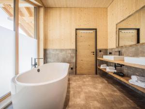 a bathroom with a large tub and a sink at Bichlbach Chalet with sauna in Bichlbach