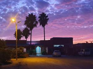a car parked in a parking lot with palm trees at Propriété La Petite Ferme in Casablanca