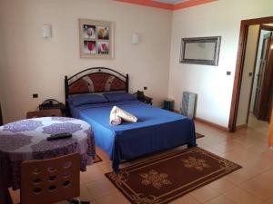 a bedroom with a bed with a blue comforter at Propriété La Petite Ferme in Casablanca