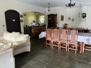 a living room with a couch and a table and chairs at Recanto Rosa Maria in Monte Sião