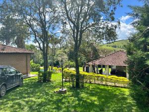 a car parked in a yard next to a house at Recanto Rosa Maria in Monte Sião