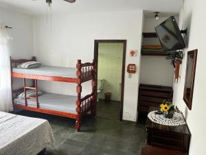 a room with two bunk beds and a television at Recanto Rosa Maria in Monte Sião +14 photos