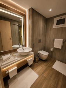 a bathroom with a sink and a toilet and a mirror at Flamingo Cairo Airport Hotel & Free Airport Pickup in Cairo