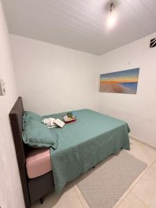 a room with a bed with a green blanket at BARRA NOVA CASCAVEL CEARÁ-Casa Solaris in Cascavel
