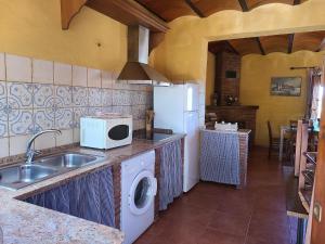a kitchen with a sink and a white microwave at Villa in Andalusia with Private Pool in Fuentes de Cesna