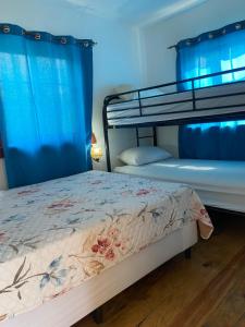 a bedroom with two bunk beds with blue curtains at Ocean breeze Villas in La Ceiba
